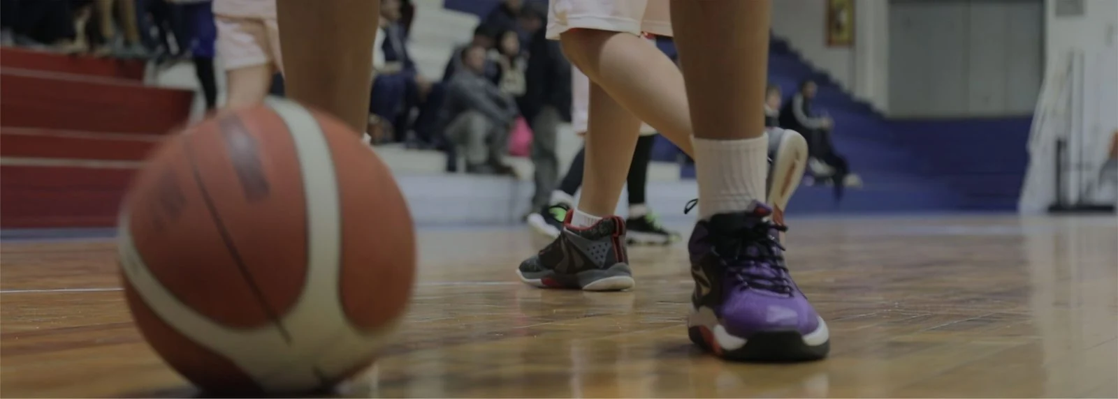 Una pelota y jugadores de básquetbol sobre la cancha del club